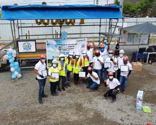 Philippines office employees wearing hard hats show off safety awards